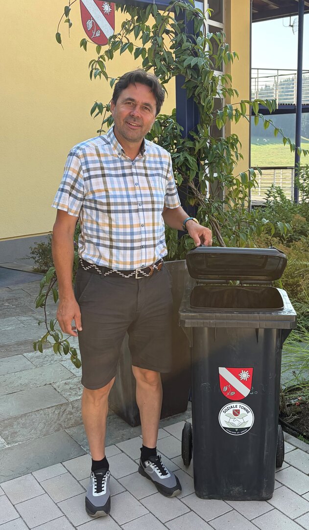 Bürgermeister Johann Gasteiner neben sozialer Tonne in St. Urban